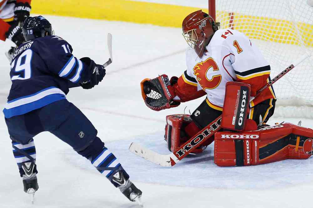 JOHN WOODS / WINNIPEG FREE PRESS
Flames goaltender Jonas Hiller robs Jets centre Jim Slater during first-period play.