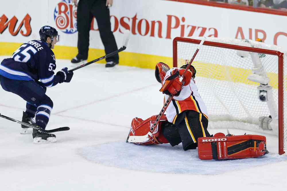 JOHN WOODS / WINNIPEG FREE PRESS
Winnipeg Jets centre Mark Scheifele scores on Calgary Flames goaltender Jonas Hiller during the first period of an NHL game at the MTS Centre in Winnipeg Sunday. The Flames downed the Jets 4-1.
