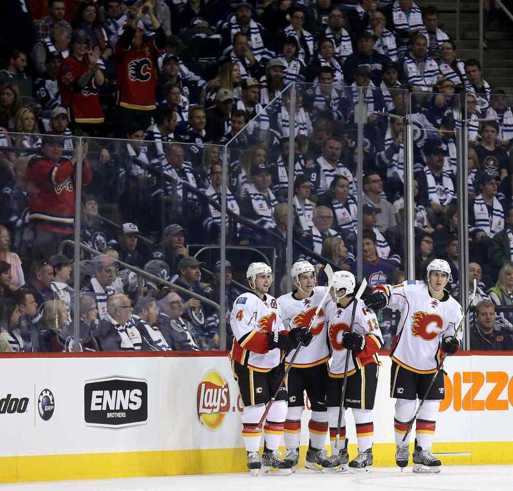 TREVOR HAGAN / THE CANADIAN PRESS
Calgary's Kris Russell (4), Mason Raymond (21), Johnny Gaudreau (13) and Mikael Backlund (11) celebrate Raymond's second-period goal.