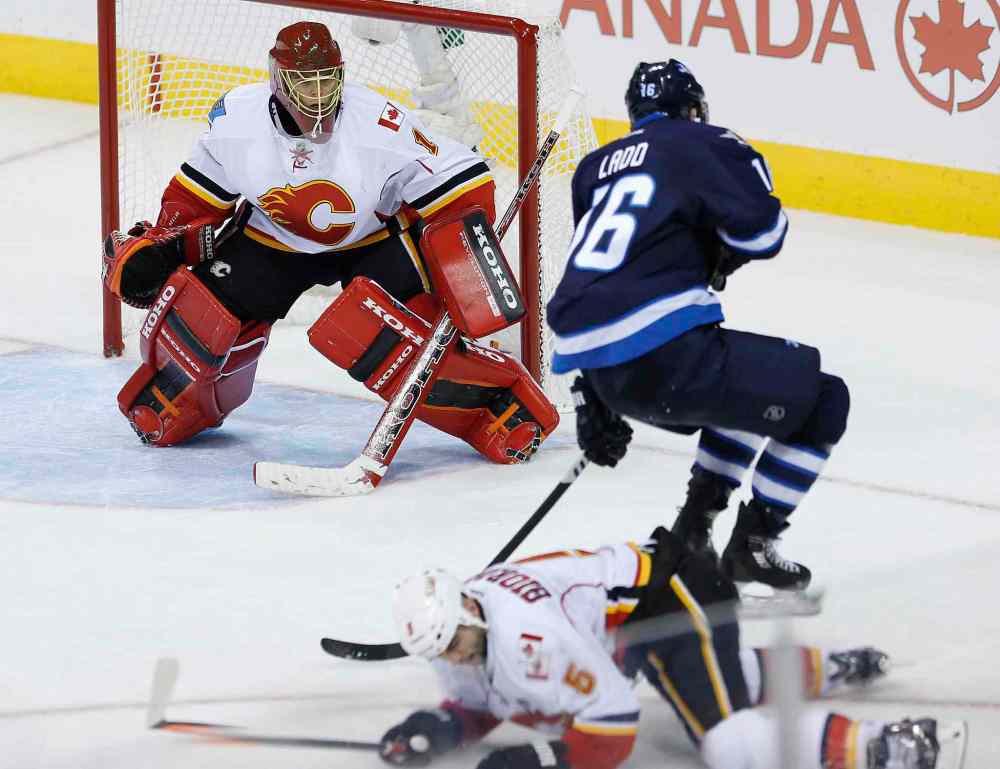JOHN WOODS / WINNIPEG FREE PRESS
Calgary goaltender Jonas Hiller watches as teammate Mark Giordano slides to break up Jets captain Andrew Ladd's third-period breakaway attempt.