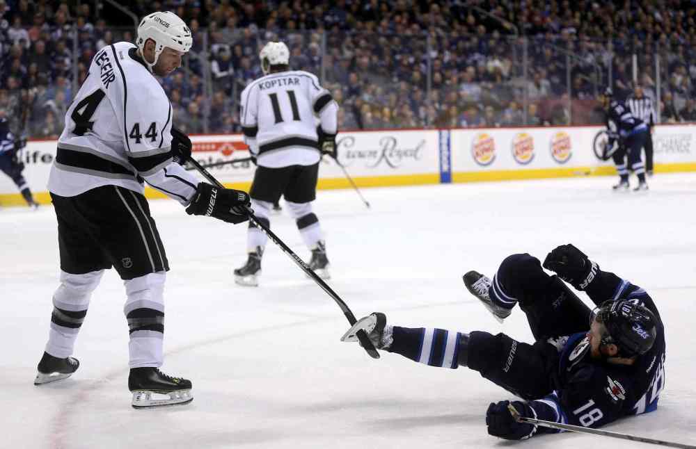 TREVOR HAGAN / THE CANADIAN PRESS
Kings defenceman Robyn Regehr has his stick tangled in Jets centre Bryan Little's skate in the second period.
