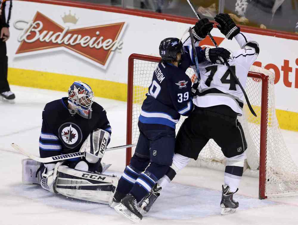 TREVOR HAGAN / THE CANADIAN PRESS
Winnipeg Jets goaltender Michael Hutchinson looks behind him as defenceman Toby Enstrom battles with Dwight King in the crease during the third period. Los Angeles Kings forward Jeff Carter, not shown, scored on the play.