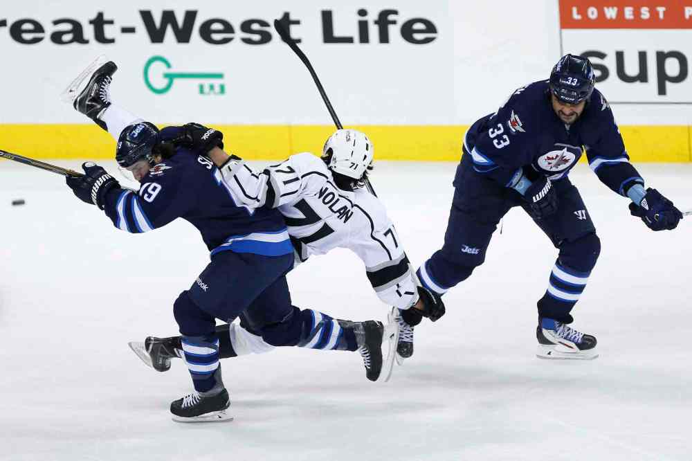 JOHN WOODS / WINNIPEG FREE PRESS
Dustin Byfuglien (33) of the Winnipeg Jets checks Jordan Nolan of the Los Angeles Kings onto the back of Jets forward Jim Slater during the third period.