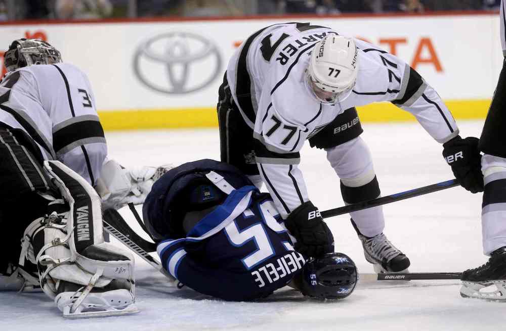 TREVOR HAGAN / THE CANADIAN PRESS
Los Angeles Kings forward Jeff Carter drives Winnipeg Jets forward Mark Scheifele into the ice during the second period.