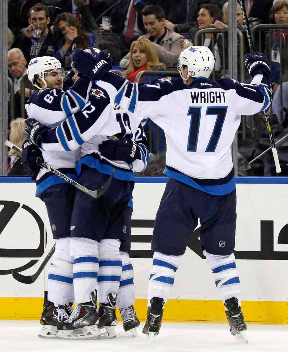 KATHY WILLENS / THE ASSOCIATED PRESS
Winnipeg Jets players Michael Frolik (from left), Olli Jokinen and James Wright celebrate a third-period goal by Jokinen.
