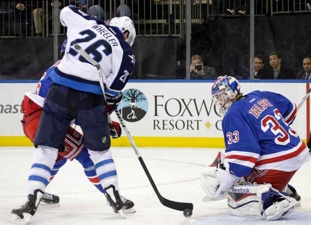 KATHY WILLENS / THE ASSOCIATED PRESS
Winnipeg Jets right-winger Blake Wheeler manoeuvres the puck in front of New York Rangers goalie Cam Talbot as he gets tangled up with defenceman Anton Stralman in the first period.