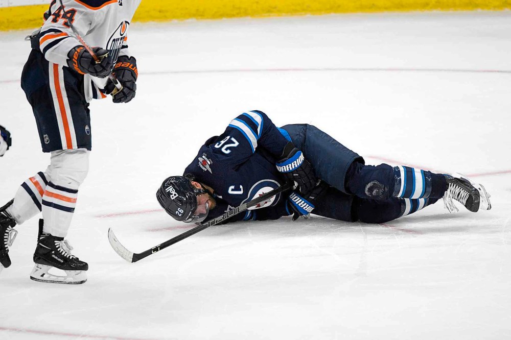 Captain Blake Wheeler lies on the ice after getting hit by a shot during the third period. (Fred Greenslade / The Canadian Press)