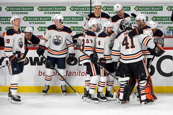 The Edmonton Oilers console goaltender Mike Smith after he allowed the game-winning goal during the third overtime period. (Fred Greenslade / The Canadian Press)