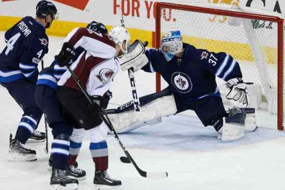 Connor Hellebuyck gets his arm to this shot by John Mitchell.