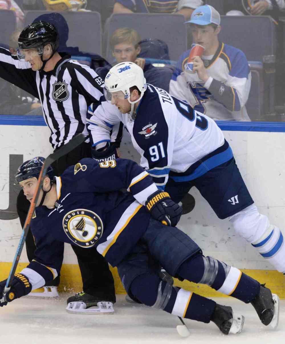 Bill Boyce / The Associated Press
St. Louis Blues' Barret Jackman (5) and Winnipeg Jets' Jiri Tlusty (91) fall in front of linesman Ryan Galloway (82) during the second period.