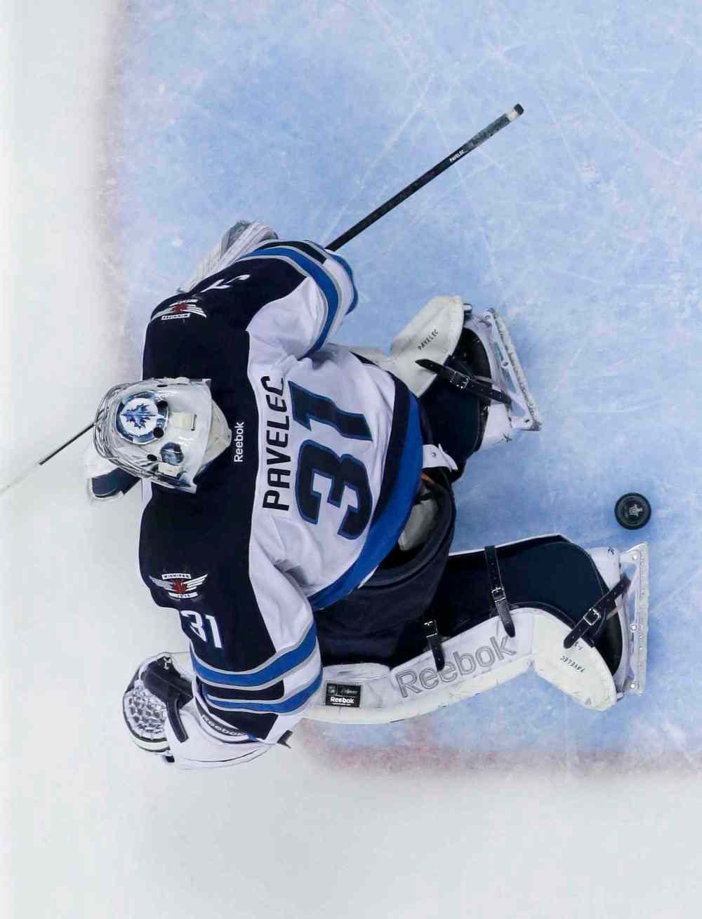 Chris Carlson / The Associated Press
The puck slips past Winnipeg Jets goalie Ondrej Pavelec for a goal by Anaheim Ducks defenceman Sami Vatanen during the first period.