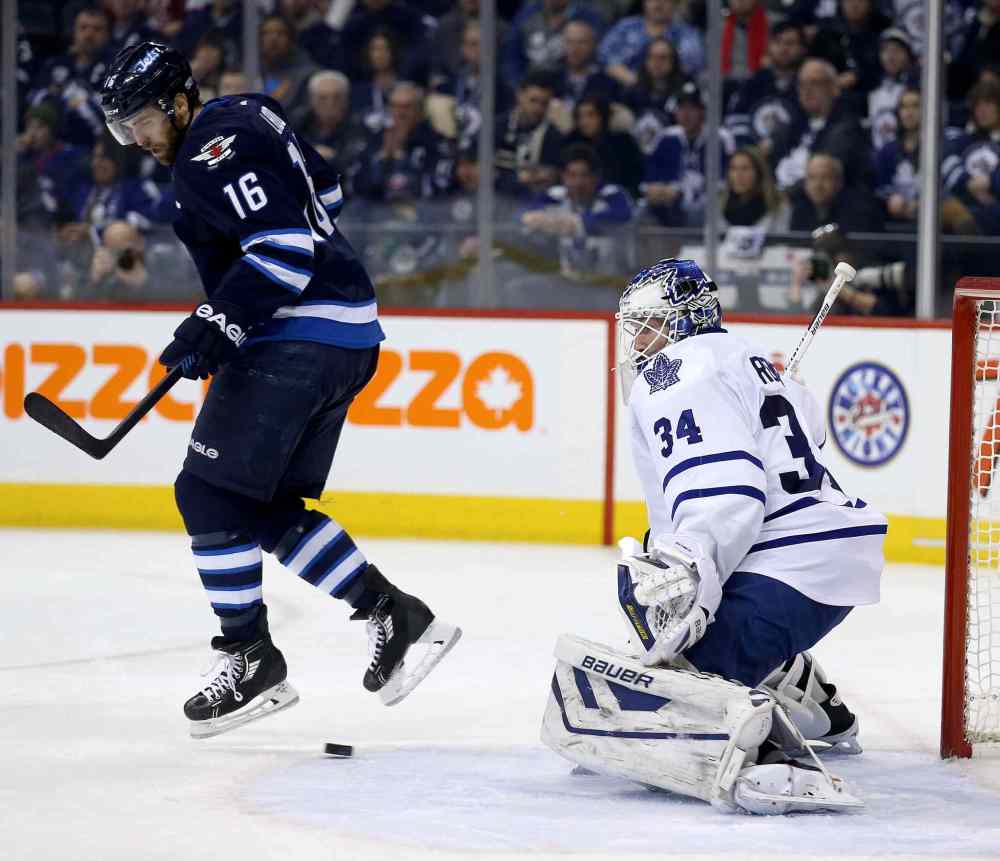 Trevor Hagan / Winnipeg Free Press
Winnipeg Jets' Andrew Ladd (16) jumps over a shot by Bryan Little (18), not shown, that gets past Toronto Maple Leafs' goaltender James Reimer (34) during second period at MTS Centre in Winnipeg Saturday.