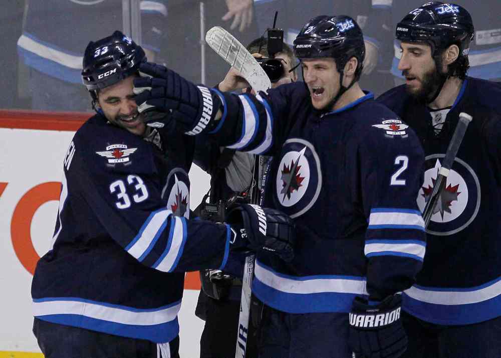 John Woods / The Canadian Press
Winnipeg Jets' Dustin Byfuglien (33) and Adam Pardy (2) celebrate Byfuglien's winning overtime goal. The Jets beat the Toronto Maple Leafs 5-4 in Winnipeg on Saturday.