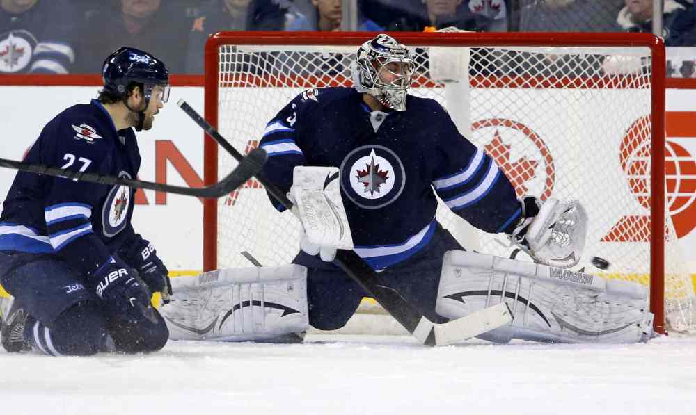 Trevor Hagan / The Canadian Press
Tampa Bay Lightning's Ondrej Palat (18), not shown, scores on Winnipeg Jets goaltender Ondrej Pavelec (31) with Eric Tangradi (27) in the crease during second period.