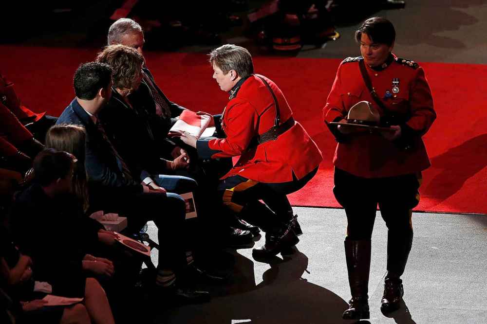 RCMP Commissioner Brenda Lucki presents a flag to the family. (John Woods / The Canadian Press)