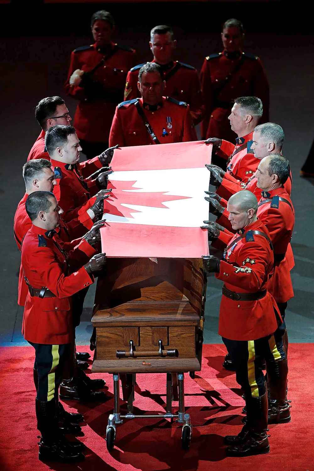 RCMP officers fold the flag. (John Woods / The Canadian Press)