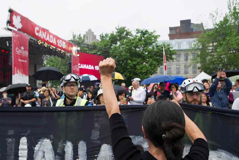 GRAHAM HUGHES / THE CANADIAN PRESS
Police hold back demonstraters during a protest in Montreal, Saturday, July 1, 2017.