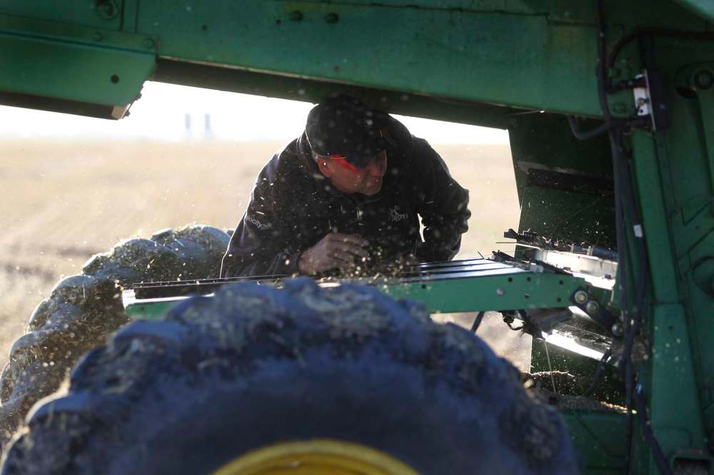 Anderson inspects the combine before Kara resumes operation.