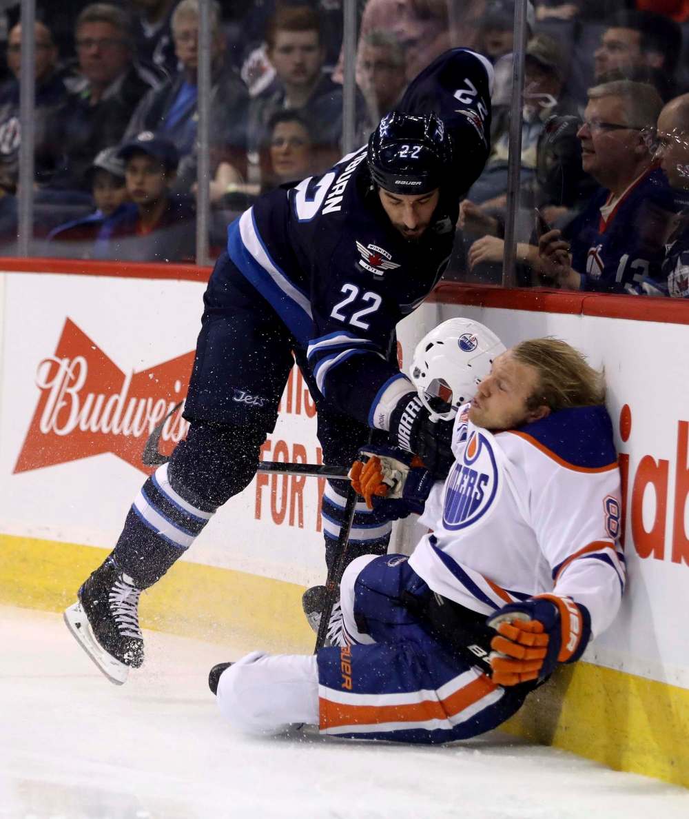 Trevor Hagan / The Canadian Press
Winnipeg Jets' Chris Thorburn (22) hits Edmonton Oilers' Griffin Reinhart (8) hard against the boards during second period pre-season NHL hockey in Winnipeg, Friday.