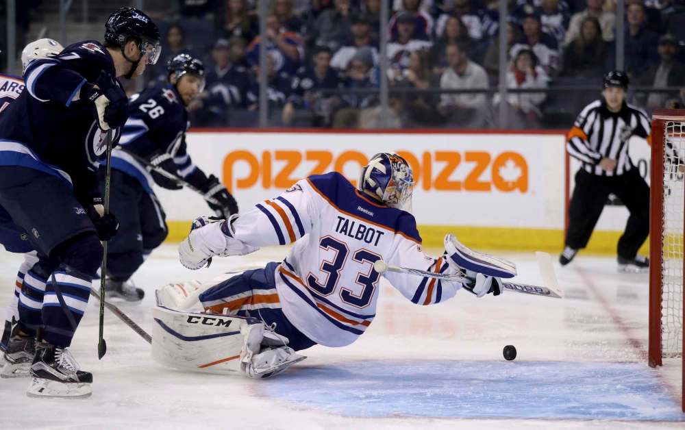 Trevor Hagan / The Canadian Press
Edmonton Oilers goaltender Cam Talbot (33) reaches back to stop the puck during second period pre-season NHL hockey against the Winnipeg Jets in Winnipeg, Friday.