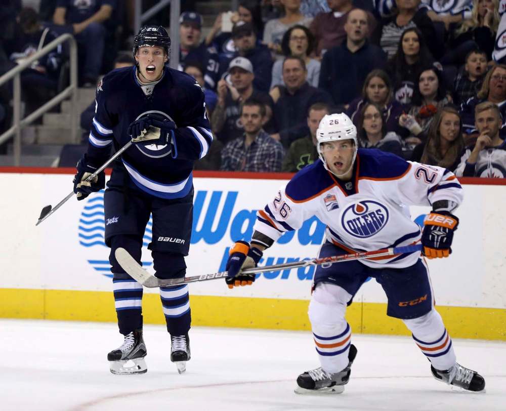 Trevor Hagan / The Canadian Press
Winnipeg Jets' Patrik Laine (29) watches the puck with Edmonton Oilers' Iiro Pakarinen (26) during second period pre-season NHL hockey in Winnipeg, Friday.