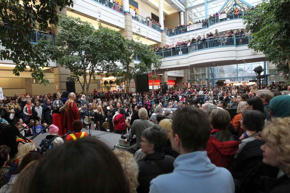 Protestors gather around centre court at Portage Place Mall to celebrate Women's Day rally and march as elder Mae Louise Campbell speaks on stage, Saturday.