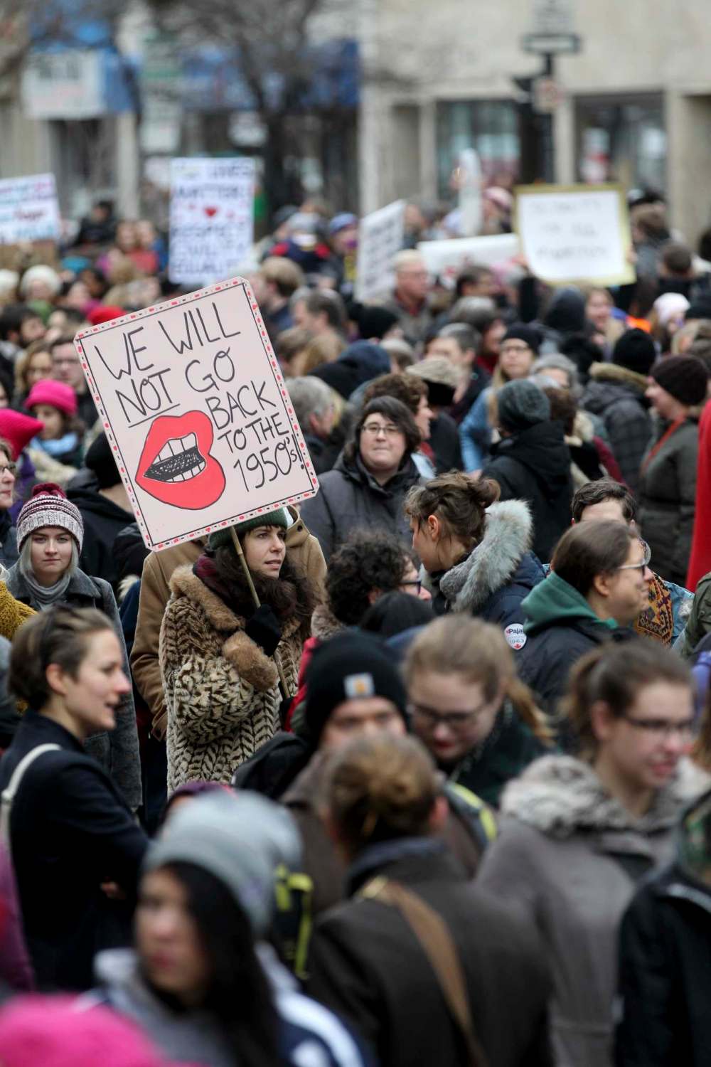 A young woman holds a sign saying, We will not go back to the 1950's, as she walks with hundreds of others down Portage Ave. Saturday.