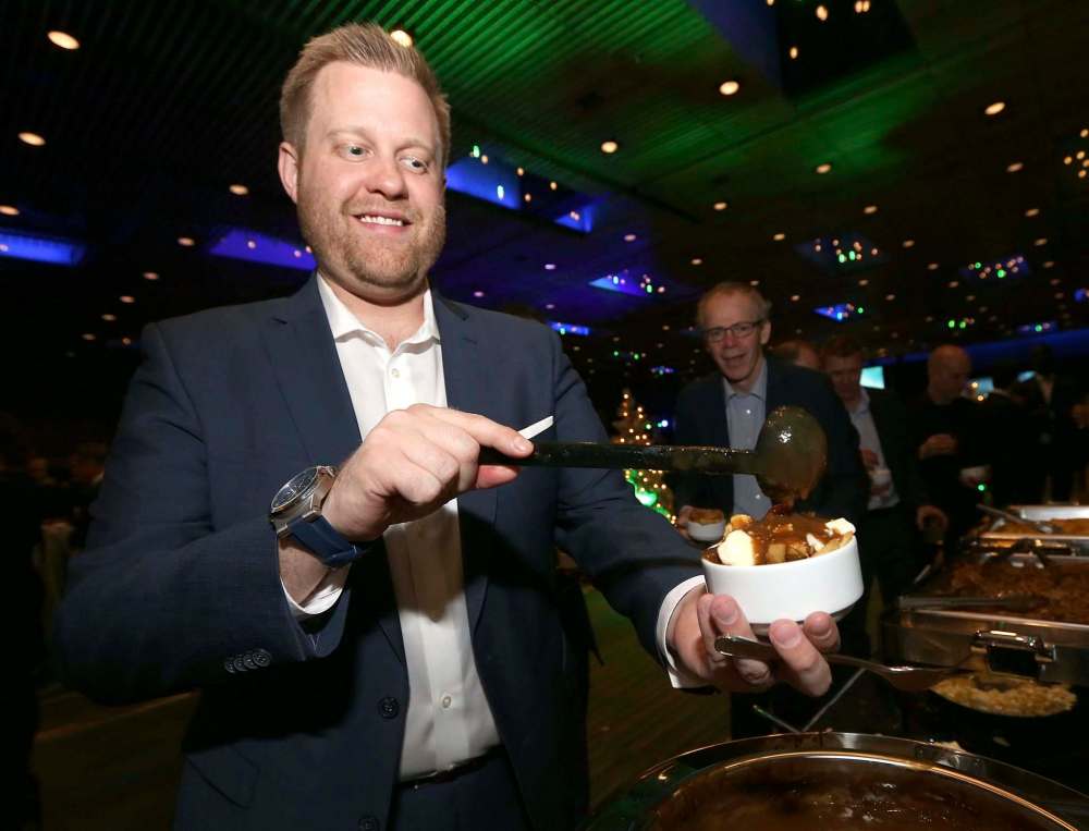 Ryan Eyer from event sponsor Birchwood BMW dresses his poutine.