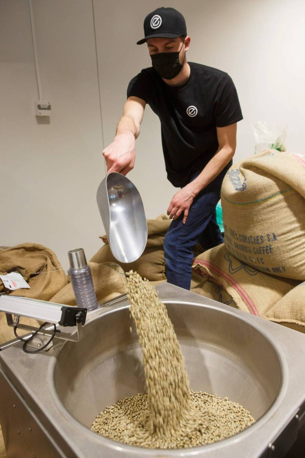 Rempel pours beans into the company roaster at the Panet Road location. (Mike Deal / Winnipeg Free Press files)