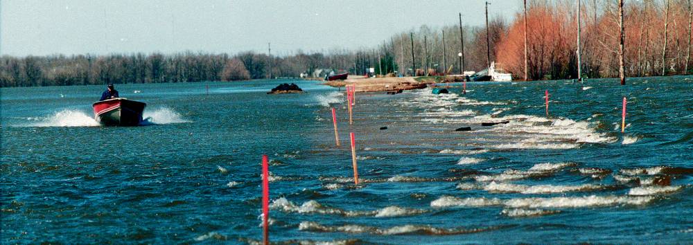 Marc Bruneau took to the water to check on his neighbours’ diked homes in Grande Pointe. (Wayne Glowacki / Winnipeg Free Press files)