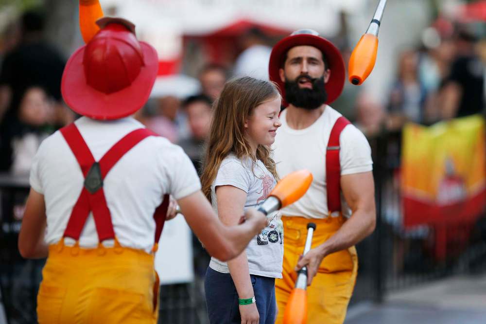 The Circus Firemen perform a juggling routine with a member from the audience.