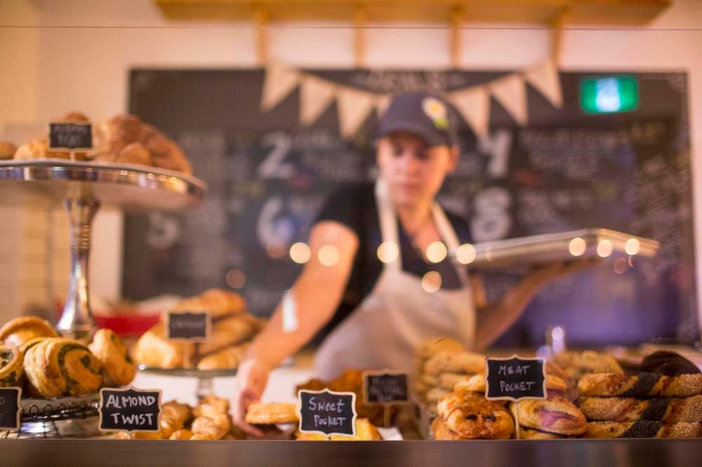 Assistant manager Brittney Albanese puts freshly baked goods into a display.