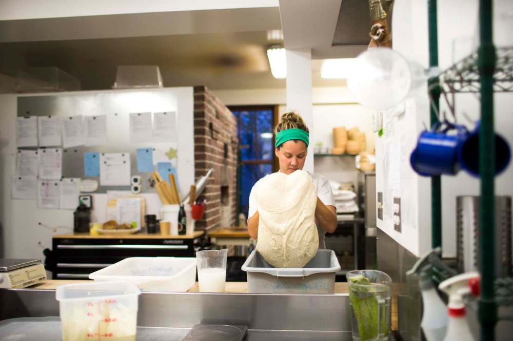 Pennyloaf owner Suzanne Gessler turns the bread dough.