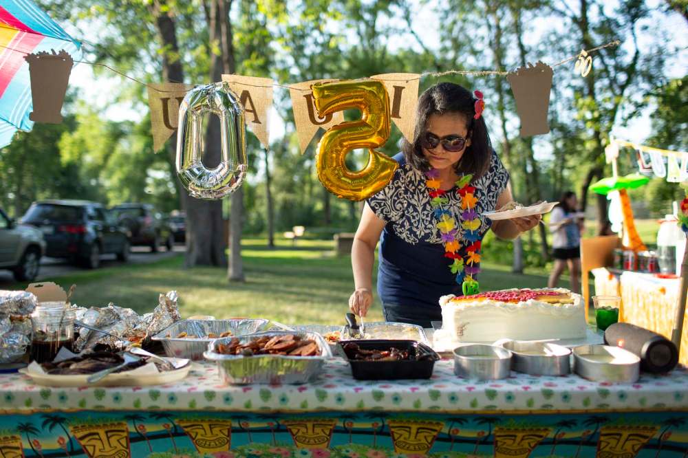 Gina Arroza serves herself last after being surprised by her family and co-workers with a 50th birthday bash in Kildonan Park.