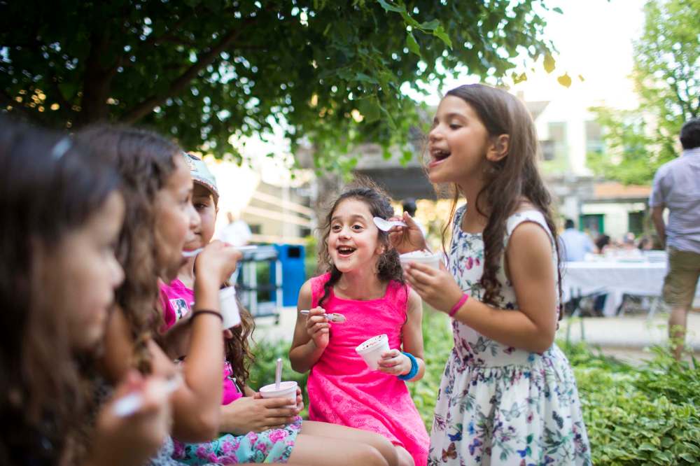 Mirell Broitan, 7 (centre), laughs while eating ice cream with friends.