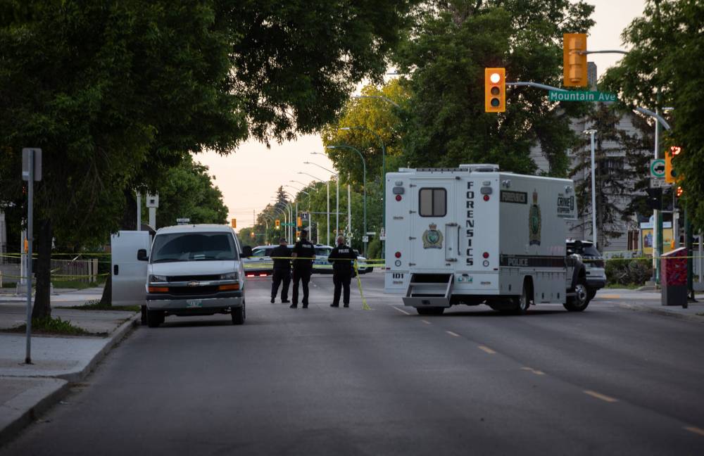 Police were present at the intersection of Mountain Avenue and Salter Street Friday evening after an officer-involved shooting left a man in critical condition but who later died in hospital. (Jessica Lee / Winnipeg Free Press)