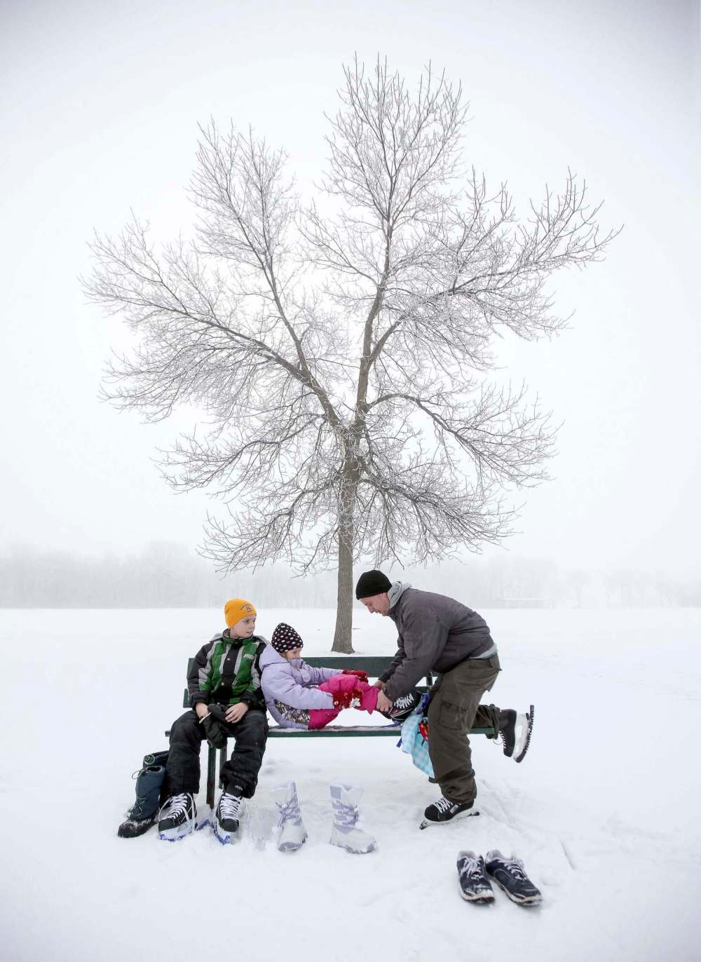 FEBRUARY 2012: Jim Craig (right) helps his daughter Larianne and son Joshua lace up before skating at St. Vital Park.