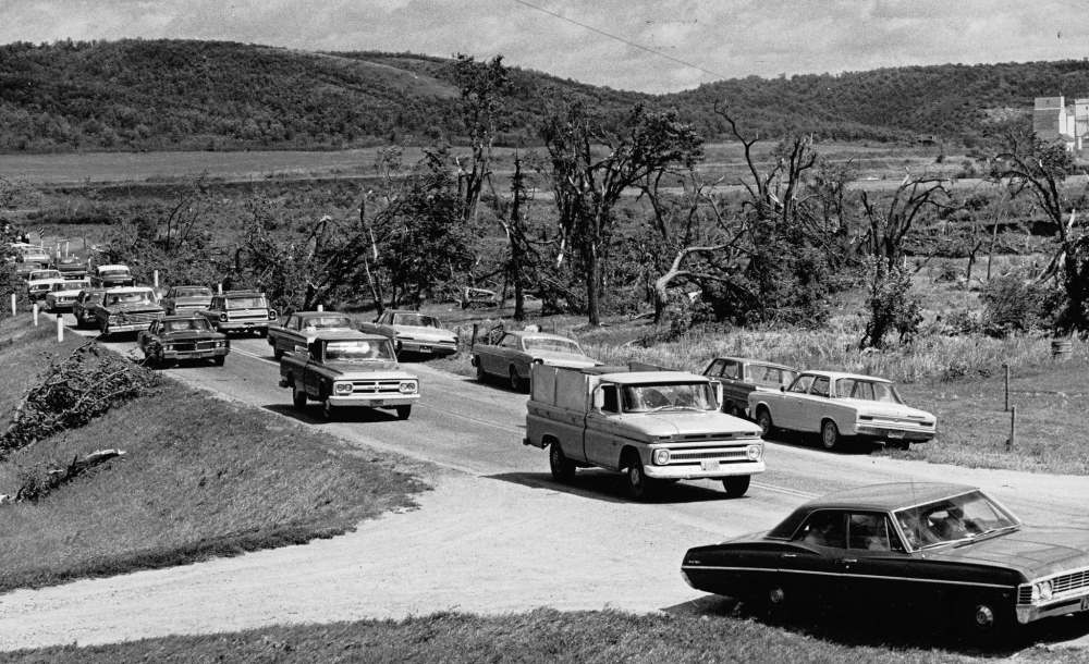 DAVE BONNER / WINNIPEG FREE PRESS
Hundreds of cars lined Highway 3 Sunday afternoon bringing sightseers to inspect the tornado damage near La Riviere. The cars are shown passing the entrance to the Holiday Mountain ski resort on the right. The trees in the background are some of the many damaged during the storm. The town of La Riviere is to the right of the grain elevators in the background.