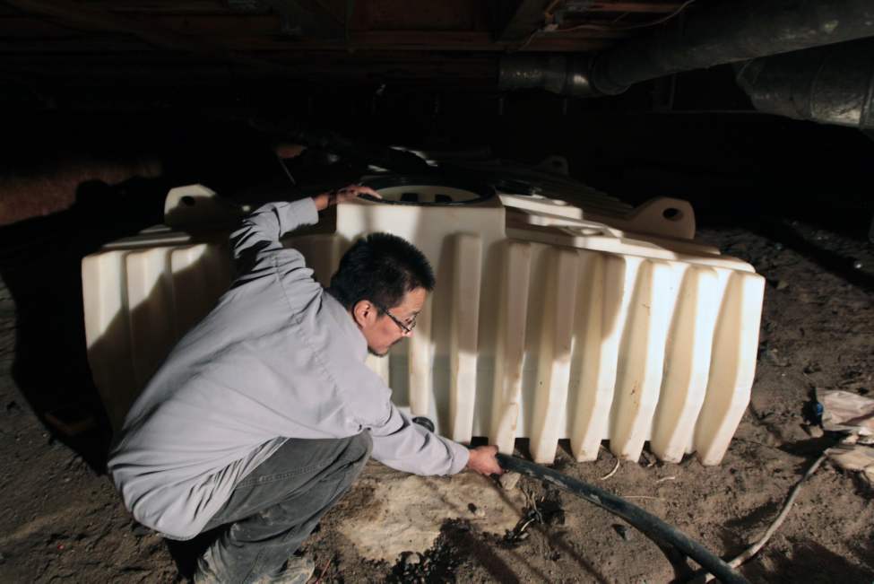 JOE.BRYKSA@FREEPRESS.MB.CA
The Little family home has a cistern that has never been cleaned by the band, which made family members sick. Water treatment plant operator Bruce McDougall checks the storage tank in a crawl space.