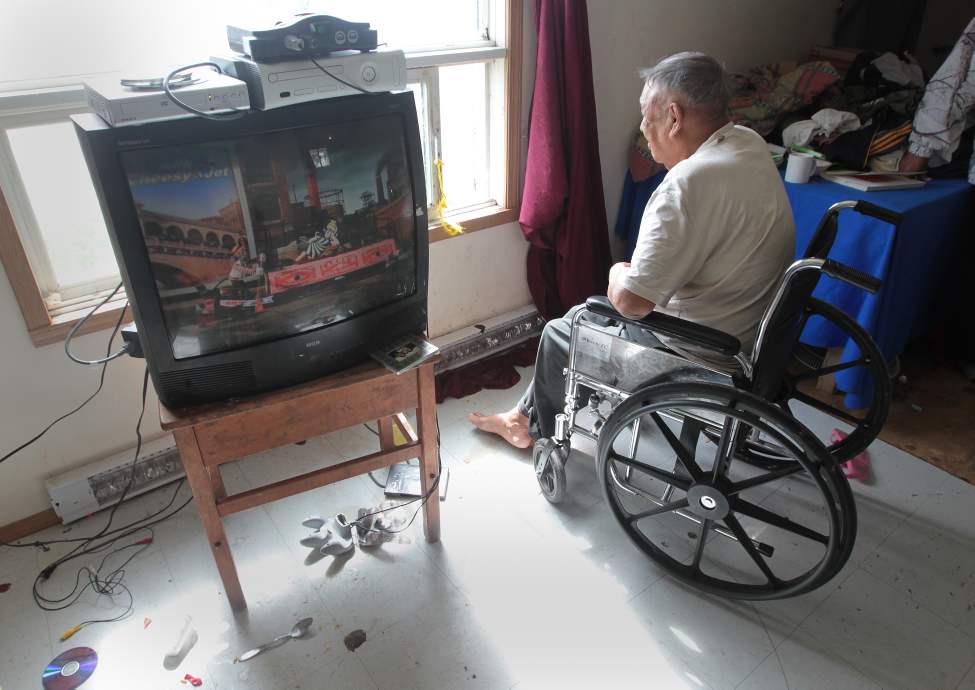 JOE.BRYKSA@FREEPRESS.MB.CA
Elder Moyer Taylor peers out a window. His son Chris thinks it's tragic that elders with disabilities are forced to live with no running water.