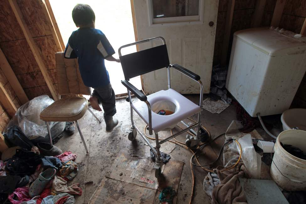 JOE.BRYKSA@FREEPRESS.MB.CA
A child runs past a makeshift toilet in elder Moyer Taylor's porch. Taylor's son Chris thinks it's tragic that elders who have disabilities have to live without running water.