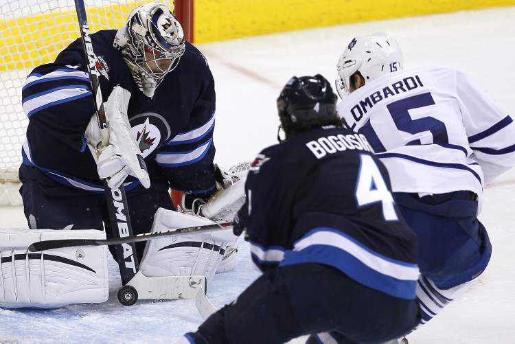 John Woods / Winnipeg Free Press
Winnipeg Jets' goaltender Ondrej Pavelec stops Toronto Maple Leafs' Matthew Lombardi (15) as Jets' Zach Bogosian comes in to cover the rebound during third-period action Tuesday.