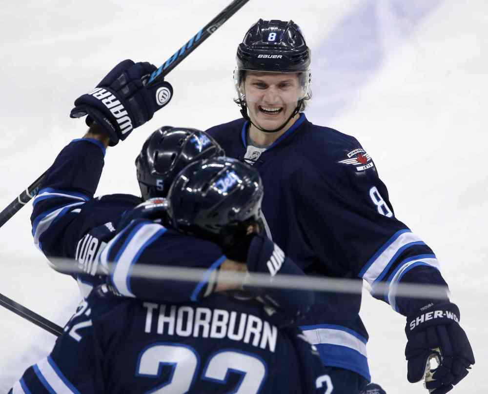 Trevor Hagan / The Canadian Press
Winnipeg Jets' Jacob Trouba (8), Mark Stuart (5) and Chris Thorburn (22) celebrate Thorburn's first goal of the season during the first period of Tuesday's game against the Nashville Predators in Winnipeg.
