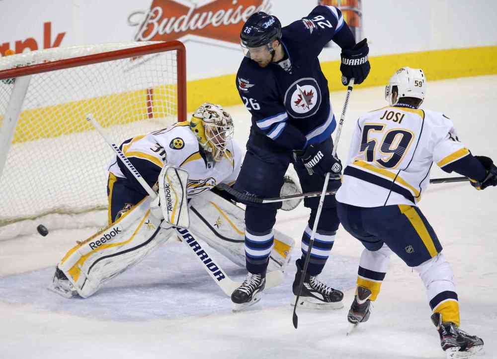 Trevor Hagan / The Canadian Press
A shot by Winnipeg Jets' Chris Thorburn (22), not shown, beats Nashville Predators' goaltender Carter Hutton (30) as Jets' Blake Wheeler (26) and Predators' Roman Josi (59) battle in front of the net during first period at Winnipeg's MTS Centre Tuesday.