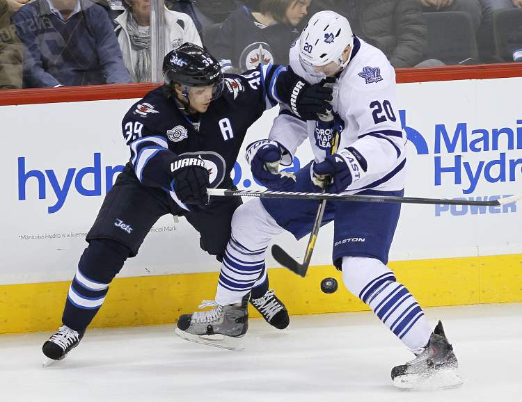 John Woods / Winnipeg Free Press
Winnipeg Jets' Tobias Enstrom (39) and Toronto Maple Leafs' David Steckel fight for the puck during third-period action Tuesday.