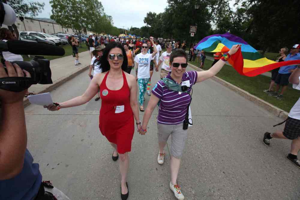 RUTH BONNEVILLE / WINNIPEG FREE PRESS
Michelle McHale and her partner Karen Phillips hold hands as they lead thousands of supporters down the streets of Steinbach.