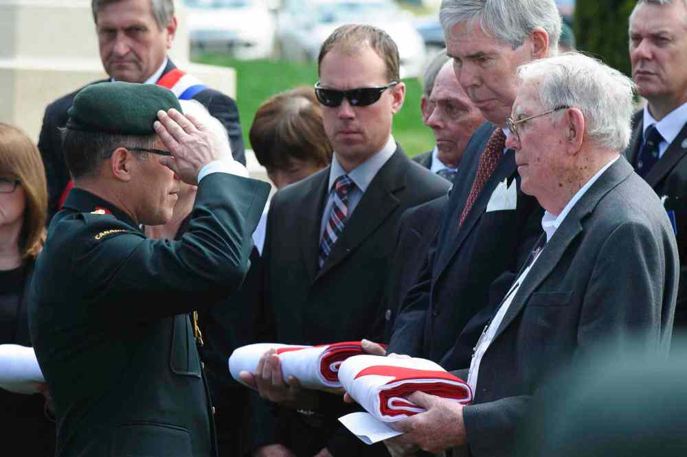 Corporal Jordan Lobb, Canadian Forces Joint Imagery Center, Ottawa
Colonel Guy Maillet, the Canadian Defence Attache Paris, salutes Clifford Teague, nephew of Lieutenant Clifford Neelands, at the burial of eight Canadian First World War soldiers from the 78th Battalion at the Caix British Cemetery in Caix, France on 13 May 2015 as part of the largest single find of unknown Canadian soldiers since the Canadian Armed Forces Casualty Identification program started in 2006.