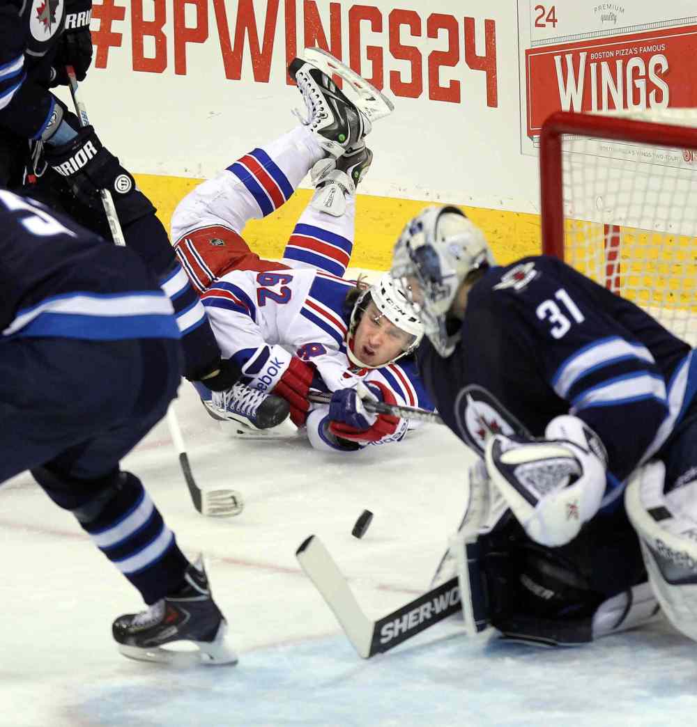 Phil Hossack / Winnipeg Free Press
New York Rangers Carl Hagelin does his best from the headstand position to push the puck past Winnipeg Jets goalie Ondrej Pavelec during second period Tuesday.