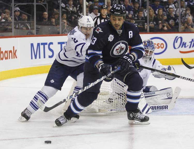John Woods / Winnipeg Free Press
Winnipeg Jets' Dustin Byfuglien (33) and Toronto Maple Leafs' Luke Schenn jostle for the puck during second-period action Tuesday.