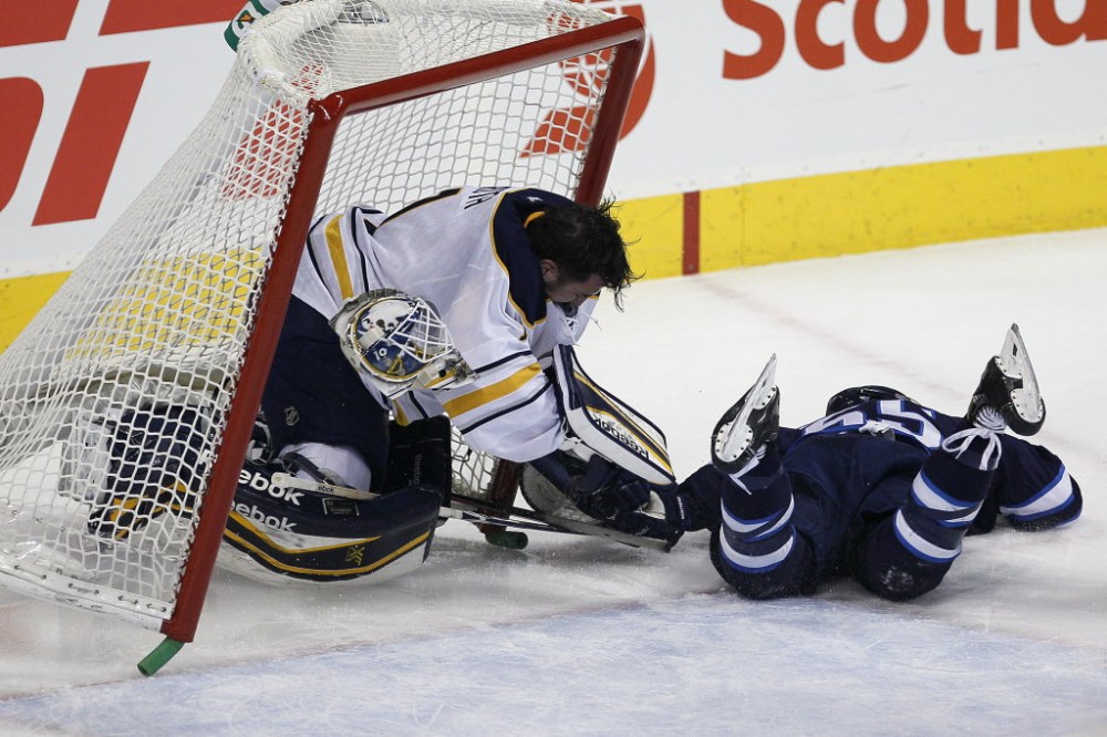 John Woods / Winnipeg Free Press
Winnipeg Jets' Mark Scheifele (#55) crashes into Buffalo Sabres' goaltender Jhonas Enroth (#1) during second period at the MTS Centre Tuesday.